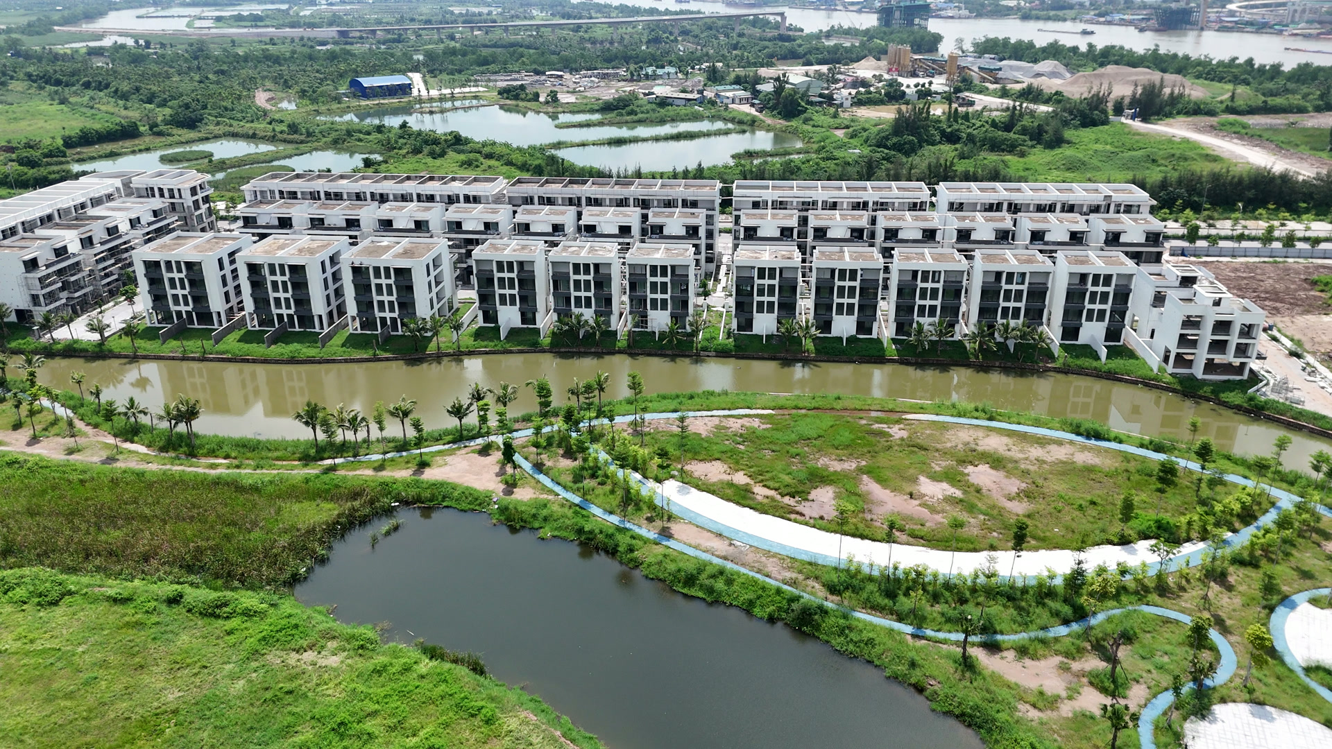 Dãy nhà thấp tầng ở Bạch Đằng 1288 đã hoàn thiện mặt ngoài, phía trước là kênh cảnh quan uốn cong với đường dạo và cây xanh hai bên