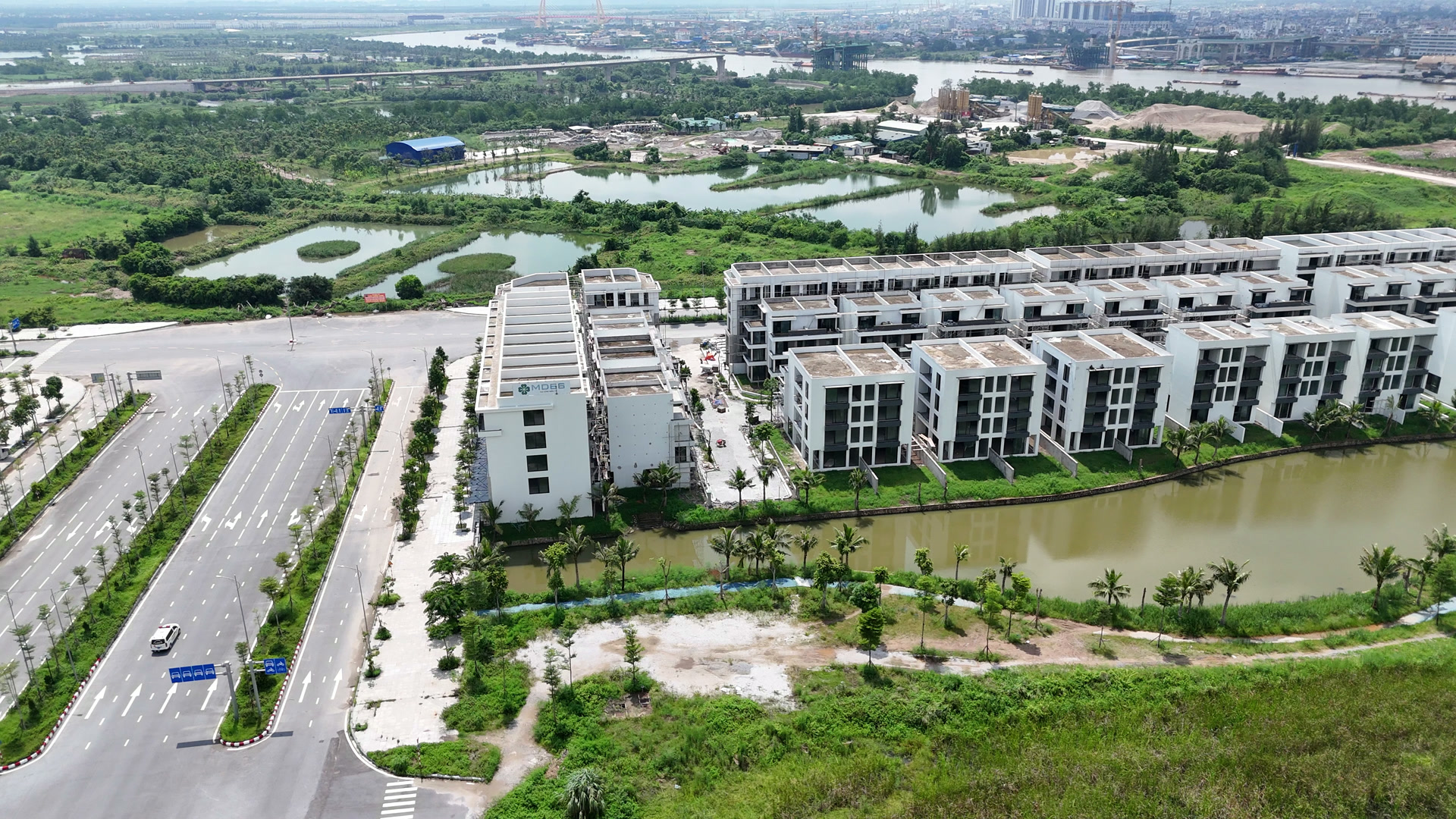 Đường lớn chạy dọc dự án Bạch Đằng 1288 với các dãy nhà thấp tầng bên phải, phía xa là sông Cấm và khu trung tâm cũ Hải Phòng