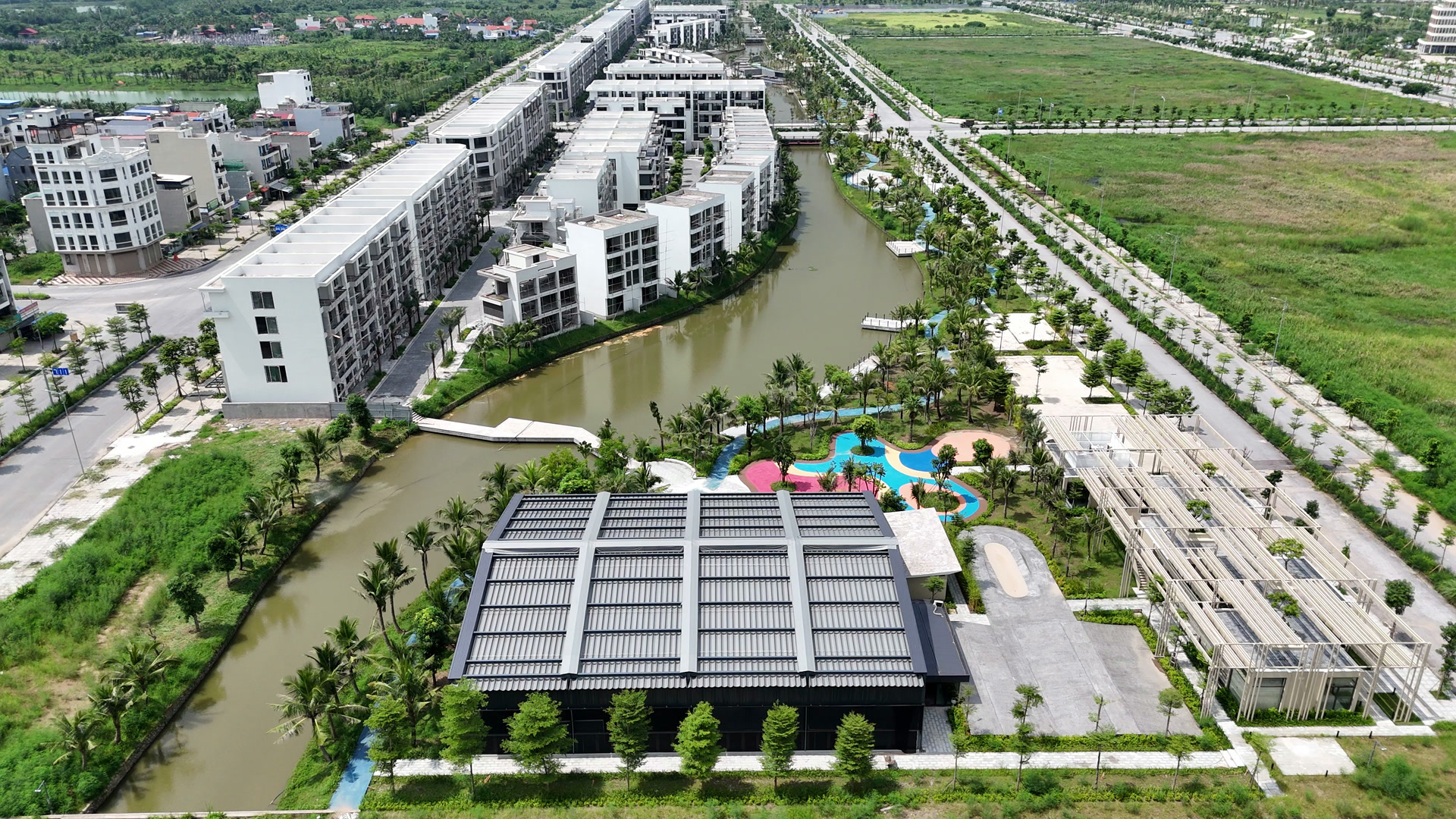 Sân chơi trẻ em nhiều màu và công trình tiện ích trong khu Bạch Đằng 1288, nằm cạnh kênh cảnh quan và các dãy nhà đã hoàn thiện