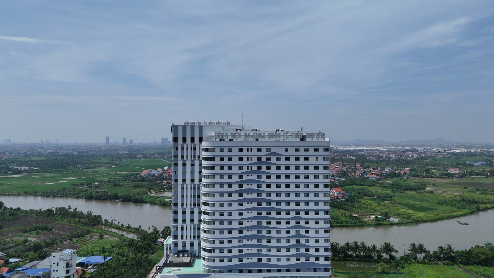 Mặt sau Bệnh viện Đa khoa Quốc tế Thủy Nguyên nhìn từ flycam, phía sau toà nhà giáp sông Trịnh, bên kia sông là ruộng và đầm