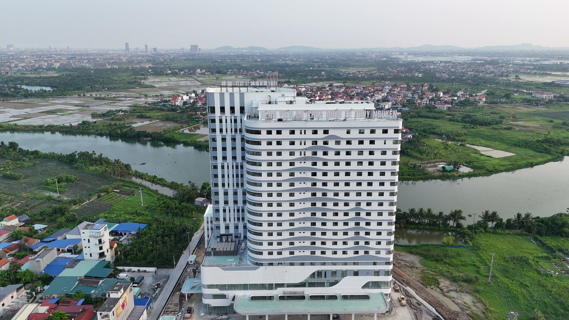 Mặt ngoài Bệnh viện Đa khoa Quốc tế Thủy Nguyên với những dải màu xám chạy ngang uốn lượn mềm mại trên nền tường trắng