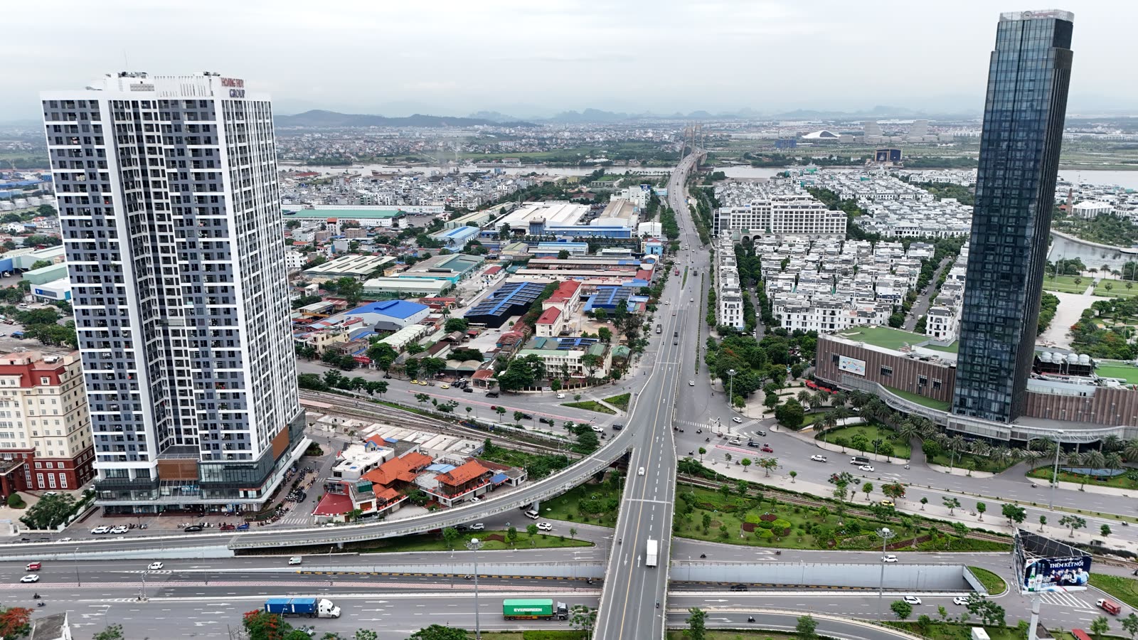Trục đường phía nội đô dẫn về cầu Bính, hai bên có nhà cao tầng, nhà liền kề và nhà xưởng