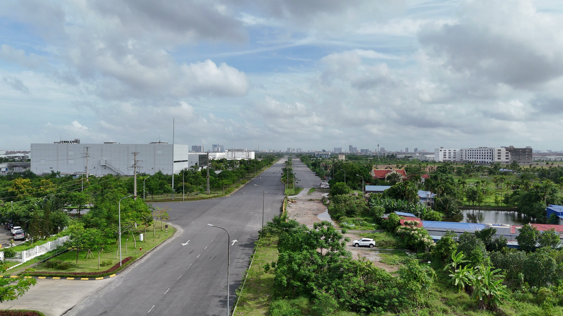 Đại lộ Bắc Nam VSIP rộng nhiều làn chạy thẳng, hai bên là nhà xưởng và đất trống, trên đường rất ít xe qua lại
