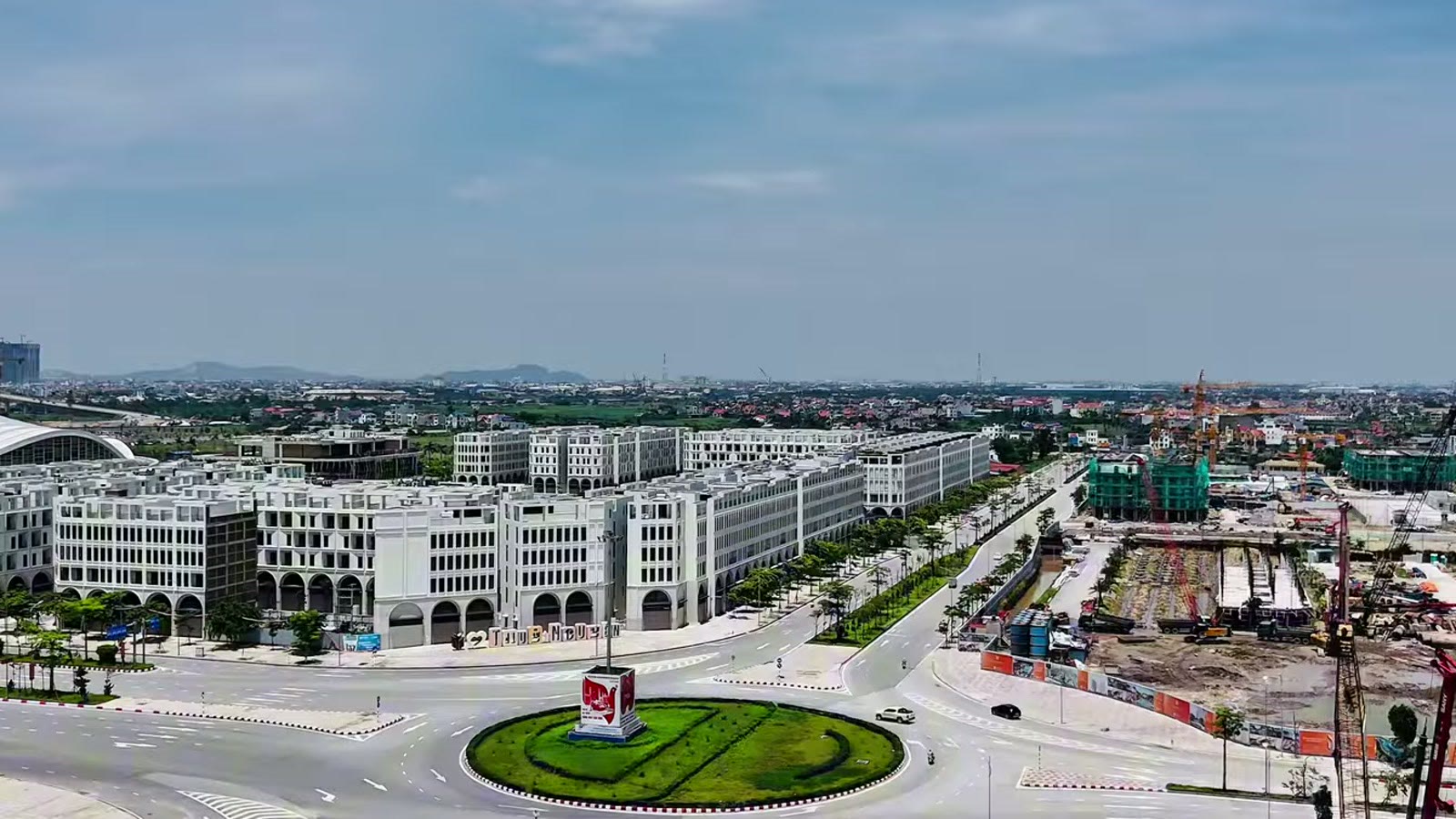 Vòng xuyến đường Đỗ Mười, một bên là dãy nhà phố nhiều tầng đã xây xong, bên kia là công trường đang thi công