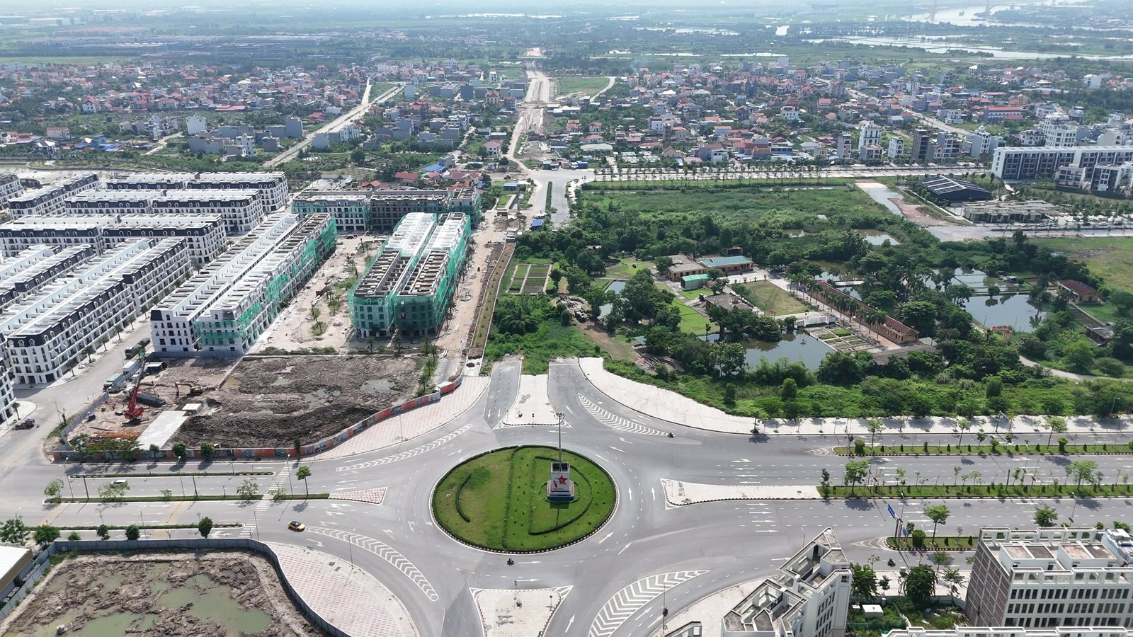 Vòng xuyến đầu tuyến đường 2,4km trên đường Đỗ Mười đã hoàn thiện, có đảo tròn trồng cây, một bên là khu đô thị nhà liền kề san sát