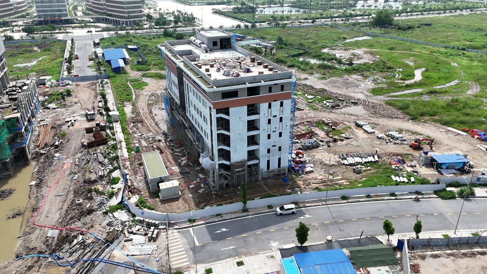 Toà nhà đầu tiên của tổ hợp giáo dục EQuest Bắc Sông Cấm đã tháo phần lớn lưới, lộ mặt tiền sơn trắng có dải viền nâu đỏ, các ô cửa sổ đã thành hình