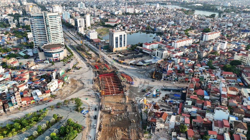 Hố hầm chui giữa nút Ngã 6 Lạc Viên Hải Phòng quây cừ, chống khung thép đỏ, nhìn dọc trục Nguyễn Trãi – Lê Hồng Phong, hai bên là phố dân cư và toà cao tầng