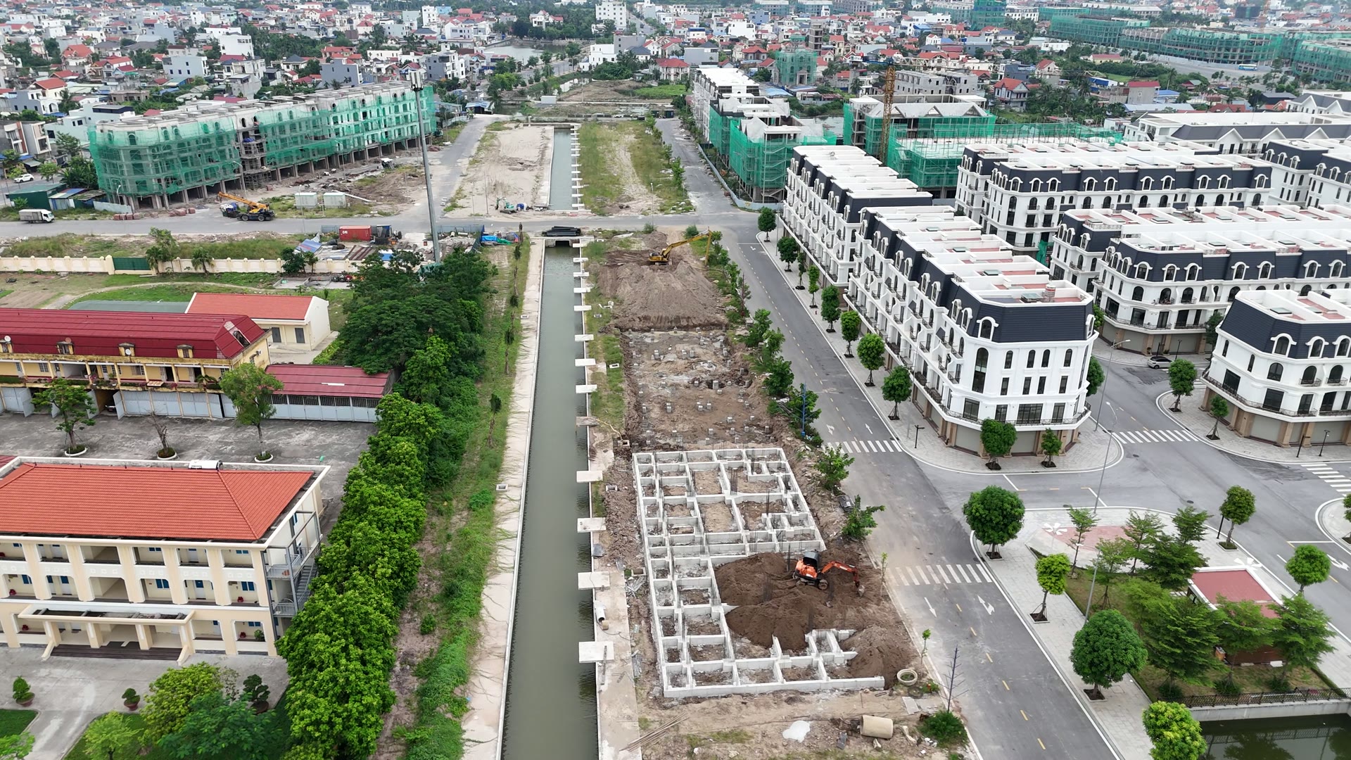 Dải đất dọc con kênh bên khu Phú Quý của Hoàng Huy New City đã có những ô móng xây thành ô vuông cho từng căn, một máy xúc đang đào tiếp phía sau, bên kia đường là dãy nhà khu Nữ Hoàng