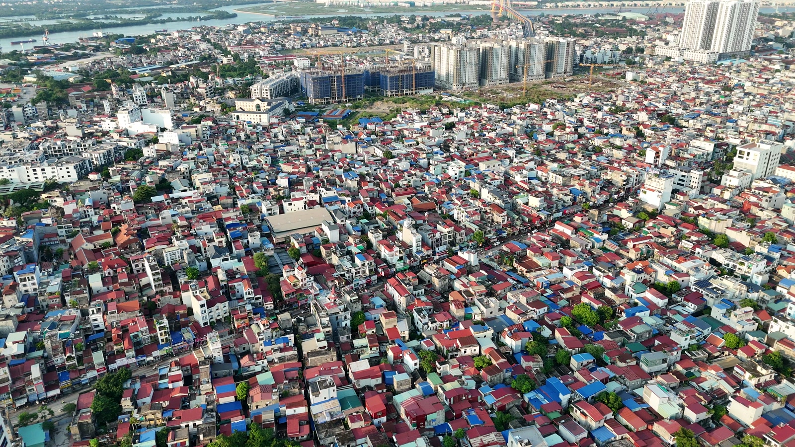 Khu phố nội đô Hải Phòng nhìn từ trên cao, nhà mái đỏ mái xanh san sát kín cả khung hình, phía xa là mấy toà chung cư cao tầng và sông Cấm