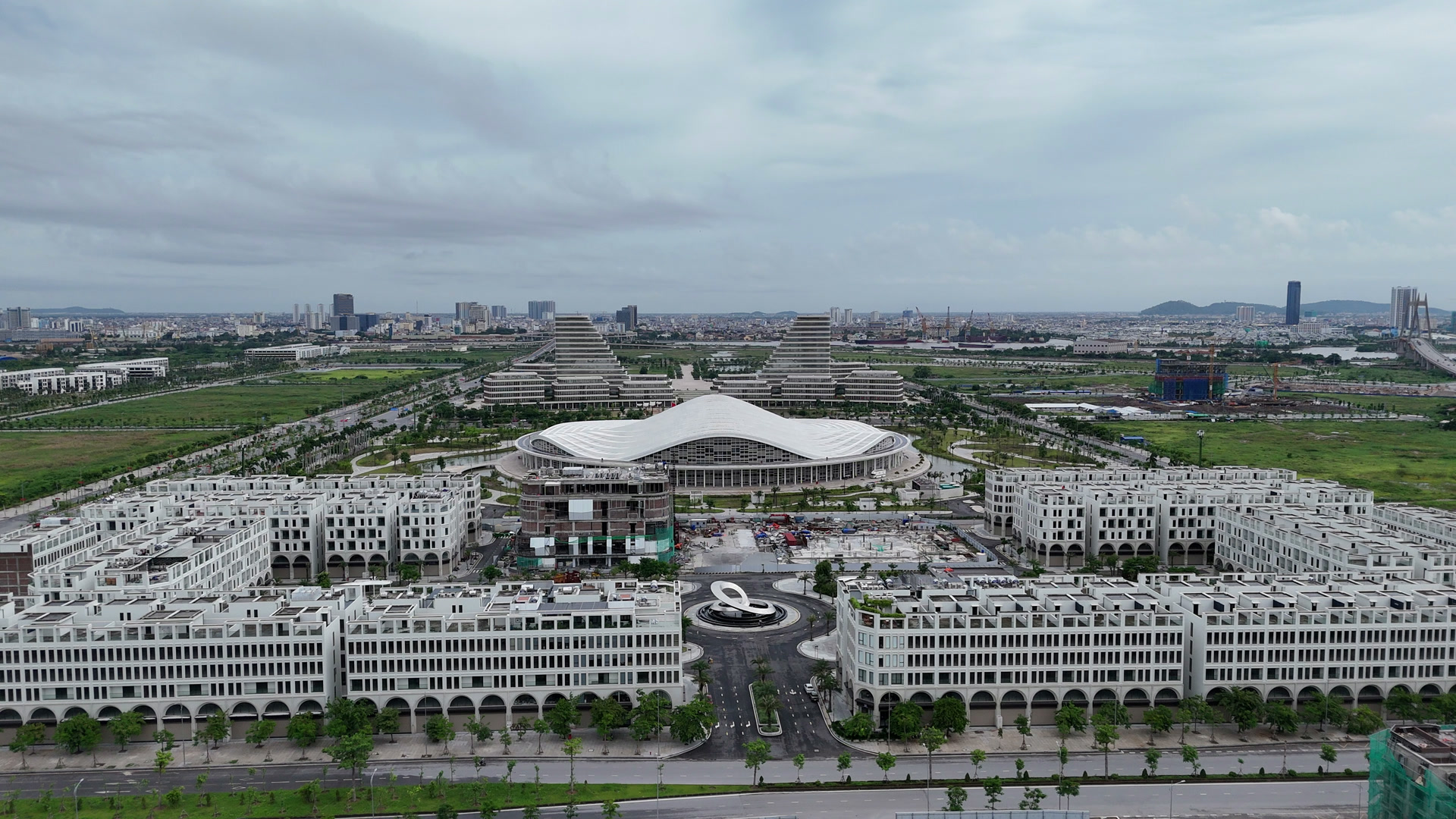 Toàn cảnh The Centric Hải Phòng với các dãy shophouse màu trắng đã hoàn thiện, phía sau là Trung tâm Hội nghị Biểu diễn mái cong và khu trung tâm hành chính