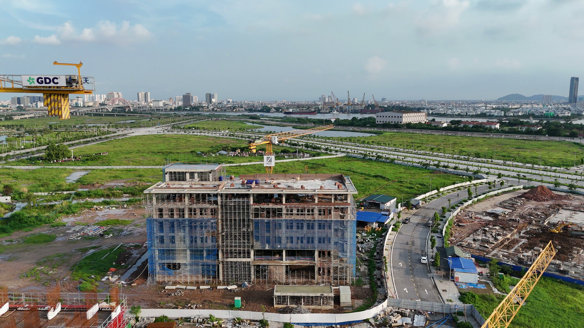 Khối nhà Tổ hợp giáo dục EQuest ở Bắc Sông Cấm đã lên sáu tầng, quây lưới xanh da trời, phía xa là sông Cấm và khu trung tâm cũ Hải Phòng