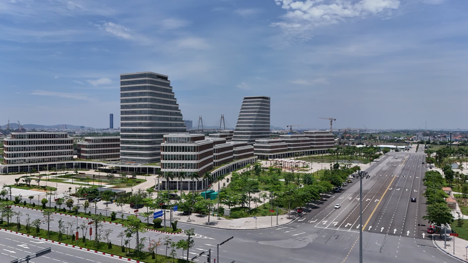 Hai khối tháp Trung tâm Chính trị Hành chính Hải Phòng nhìn gần, phía trước là đường lớn và cây xanh