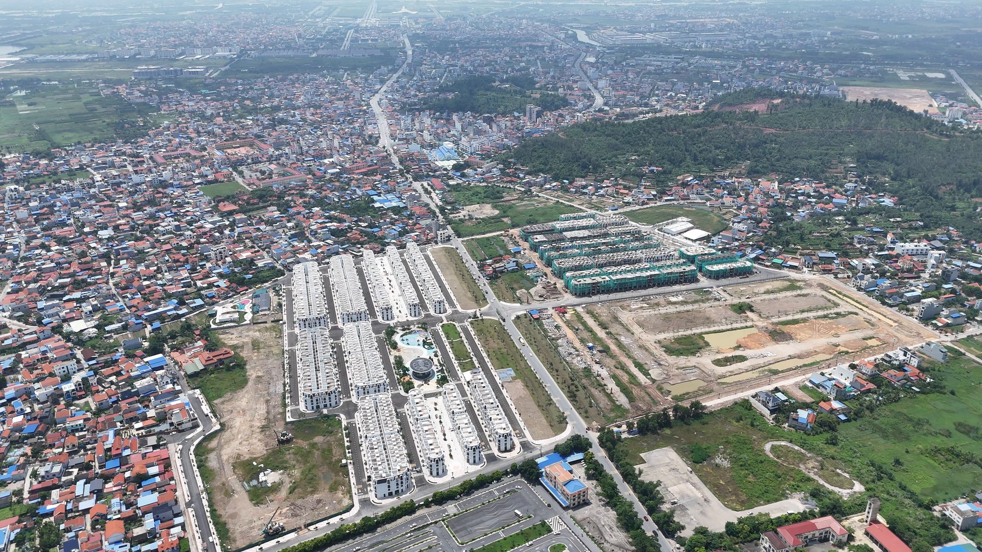 Khu đô thị Vlasta Hải Phòng nhìn từ xa, các dãy nhà của dự án nằm ngay cạnh khu dân cư hiện hữu của Thủy Nguyên với mái nhà san sát và đường làng