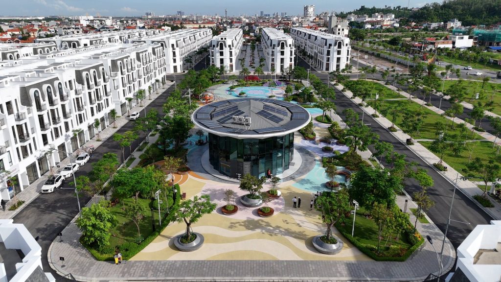 Quảng trường nghệ thuật Ngân Hà trong khu đô thị Vlasta Hải Phòng nhìn từ trên xuống, sân lát nhiều màu, cây xanh và lối đi bộ, hai bên là các dãy nhà thấp tầng màu trắng