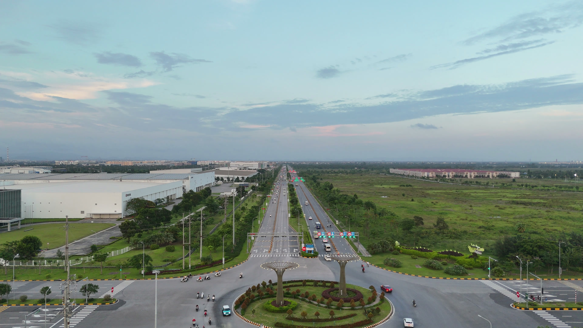 Vòng xuyến lớn trên tuyến 9C nơi gặp trục Bắc Nam VSIP, xung quanh là nhà xưởng khu công nghiệp và đất còn trống