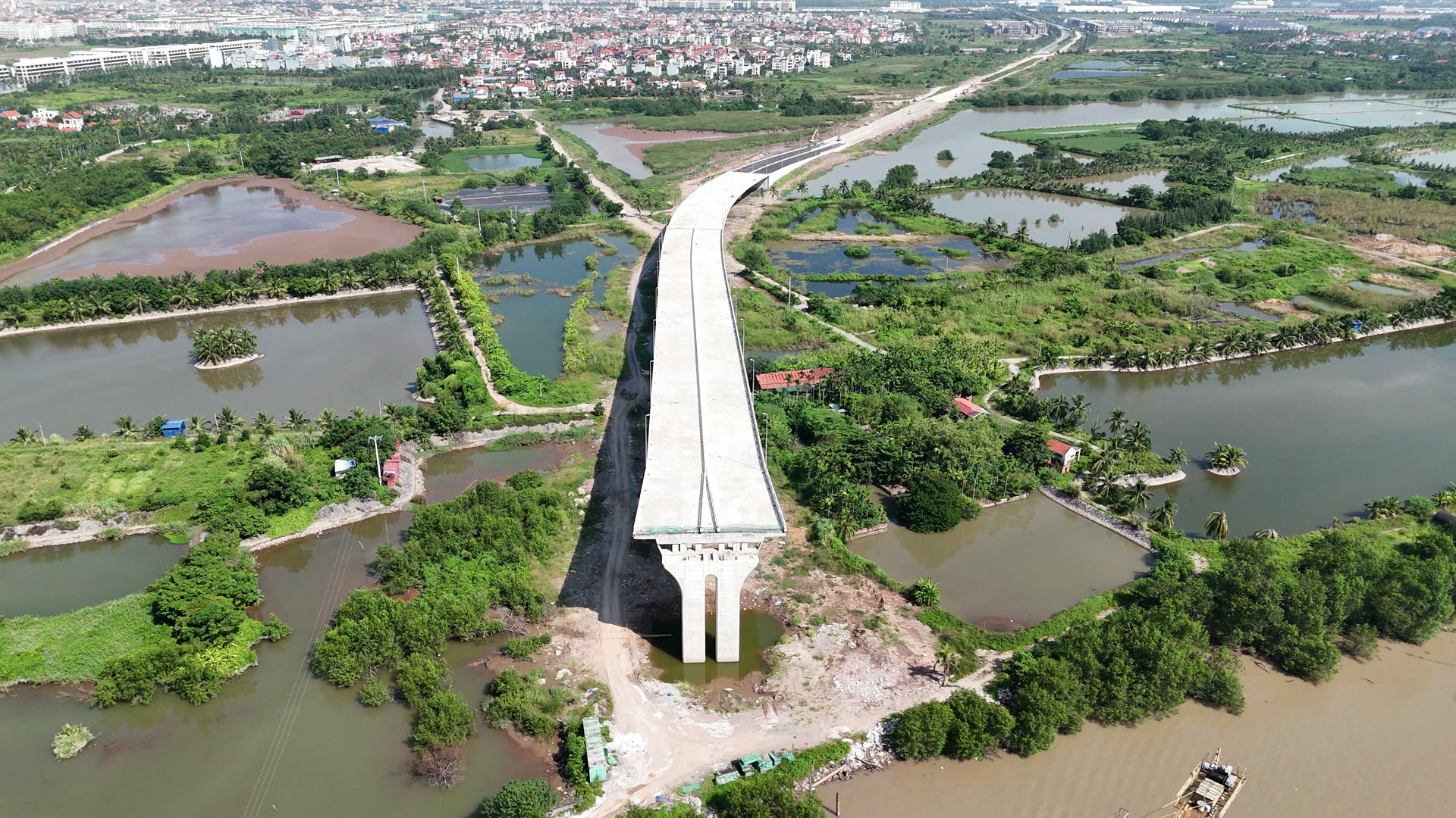 Cầu dẫn cầu Nguyễn Trãi phía Thủy Nguyên chạy qua vùng ao đầm nuôi, nối vào đoạn đường dẫn đã trải nhựa phía xa
