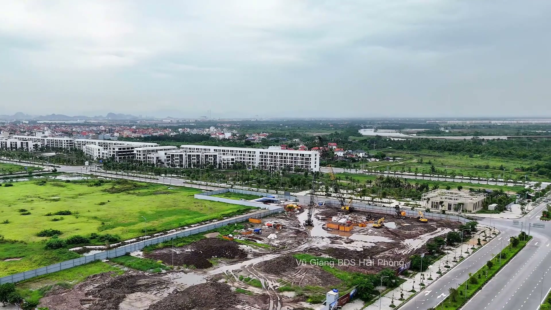 Lô Doji 75 Complex tháng 6/2026 đã quây rào, bên trong đào dở với nhiều đống đất mới xúc, máy xúc vàng và cần cẩu đang làm, phía sau là dãy nhà phố trắng