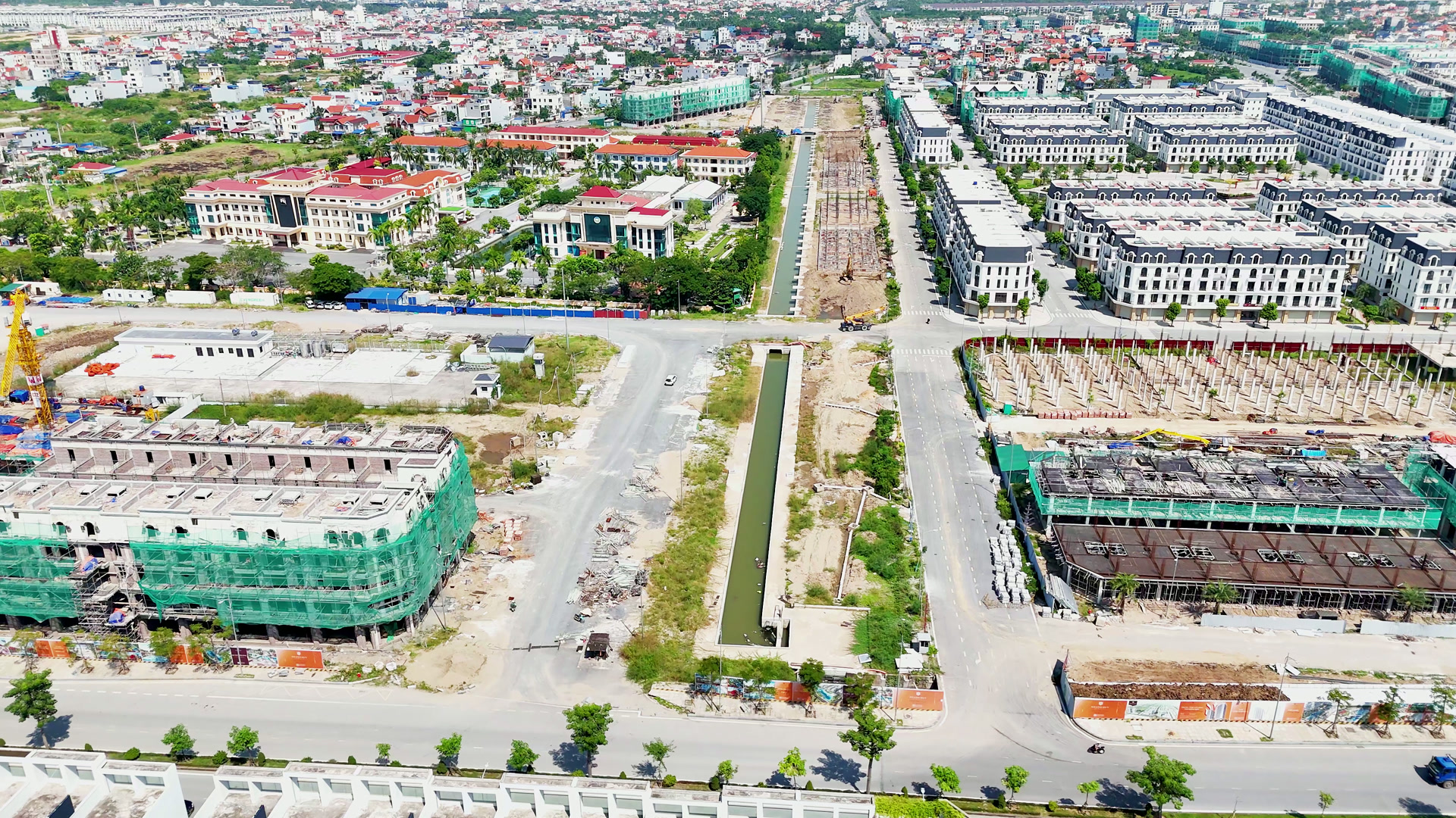 Con kênh thẳng chạy giữa Hoàng Huy New City, bên phải là một vạt đất đã dựng hàng cột bê tông, phía xa dọc kênh vẫn là đất đang làm