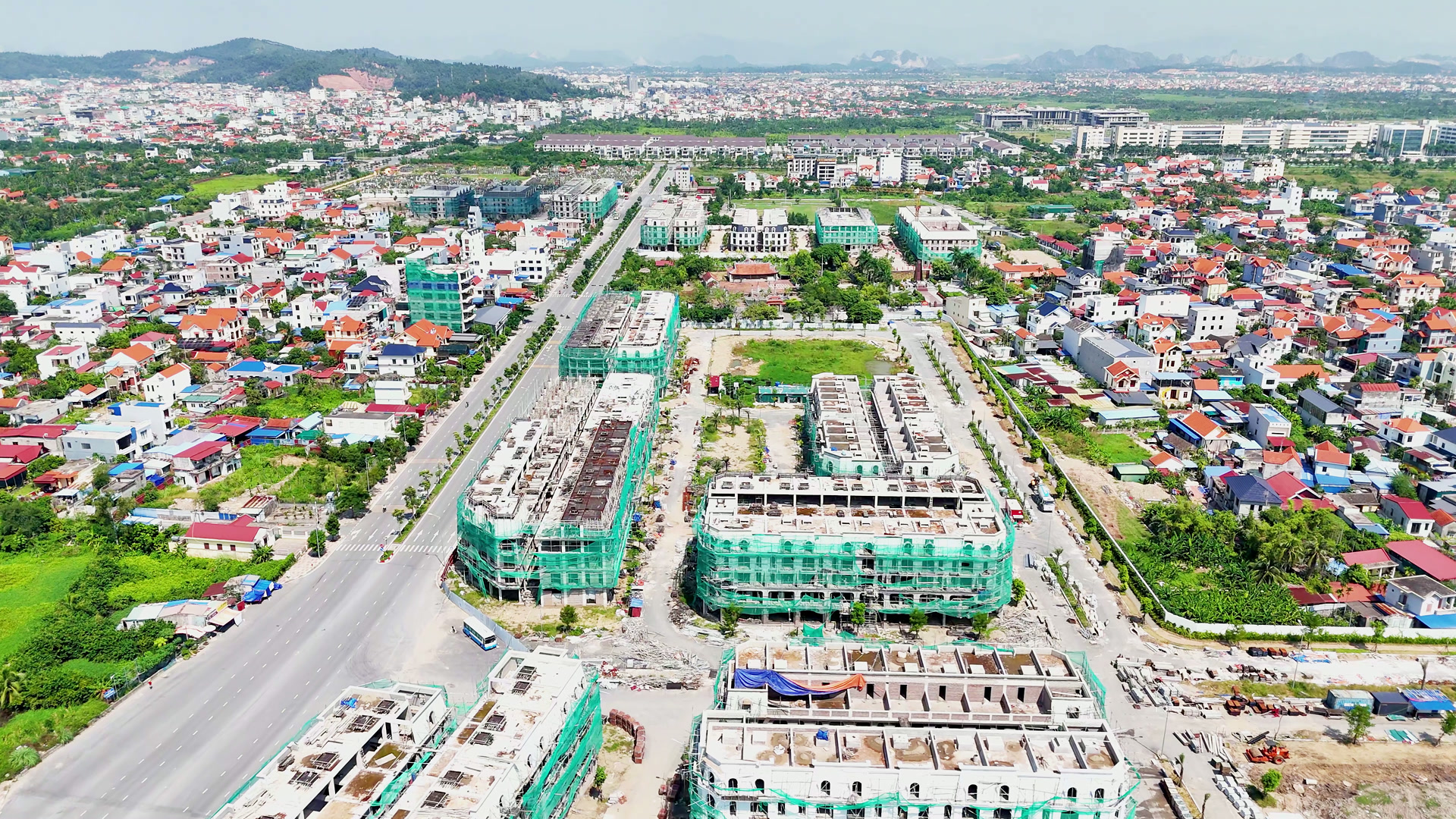 Những dãy nhà phố còn bọc lưới xanh ở rìa Hoàng Huy New City, ngay bên cạnh là khu dân cư cũ nhà mái đỏ xen vườn cây