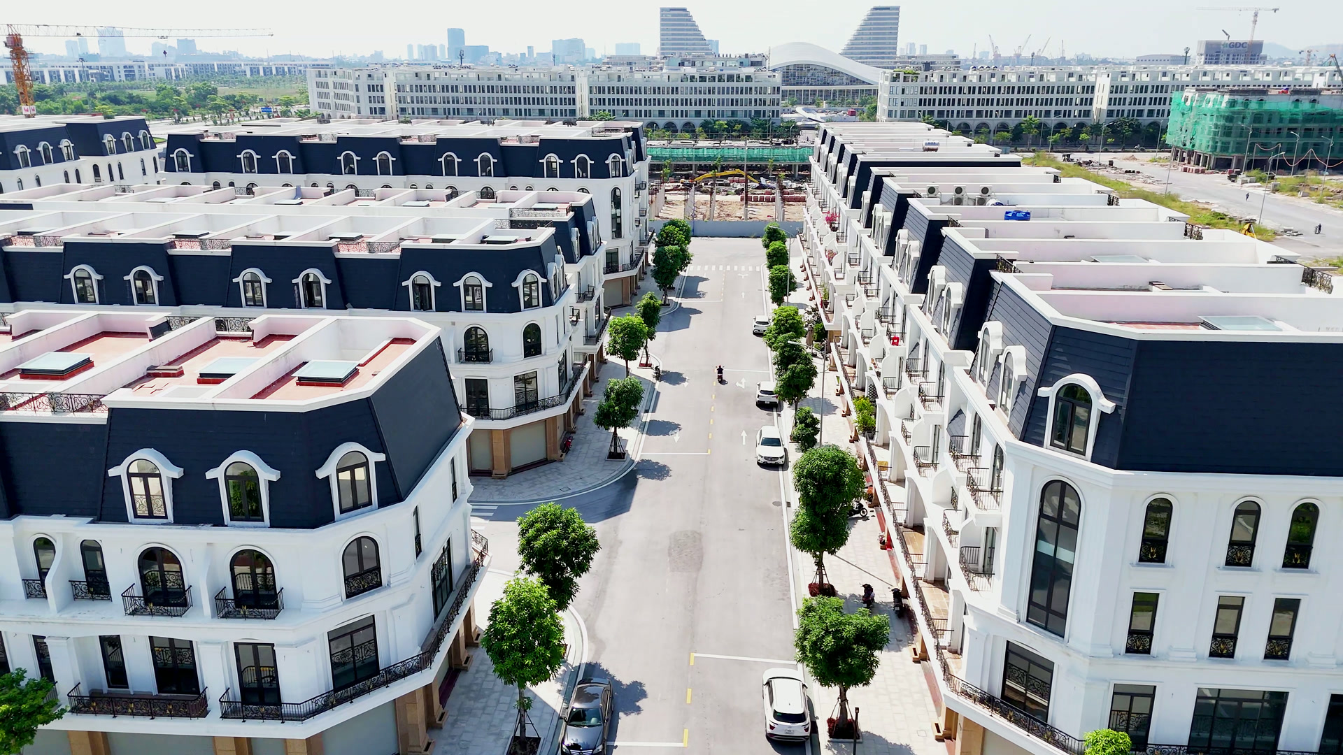 Đường nội khu ở Hoàng Huy New City, hai bên là những dãy nhà phố mặt trắng mái đen đã có người ở, hàng cây xanh trồng dọc đường