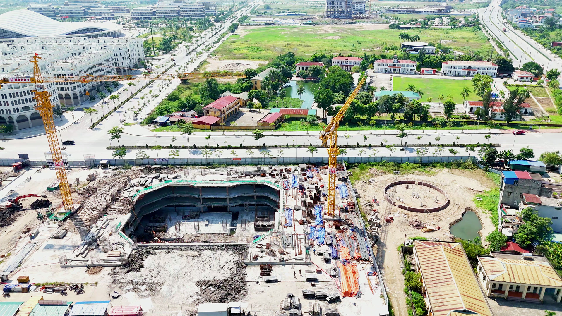 Hố đào tầng hầm sâu của khu cao tầng ở Hoàng Huy New City, thành hố lộ mảng bê tông, cần cẩu tháp màu vàng đứng hai bên, vật tư xếp quanh mép công trường